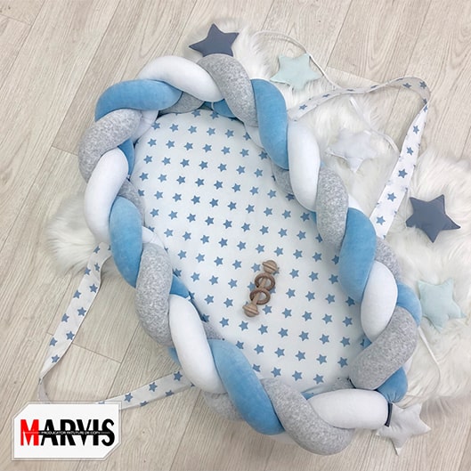 Baby Nest Braid Blue, vedere de sus Baby Nest Braid Blue cu împletitură bleu, gri și albă și saltea albă cu steluțe bleu, vedere de sus