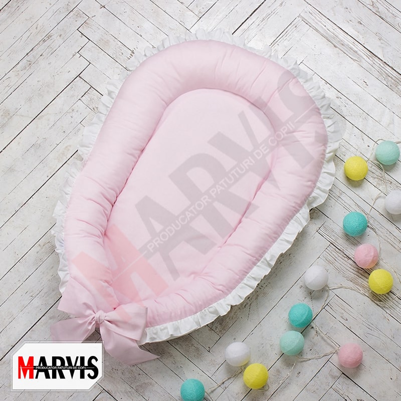 Baby Nest Roz, fața roz Baby Nest Roz pe fața roz pal, cu volănaș alb și fundă roz, vedere de sus