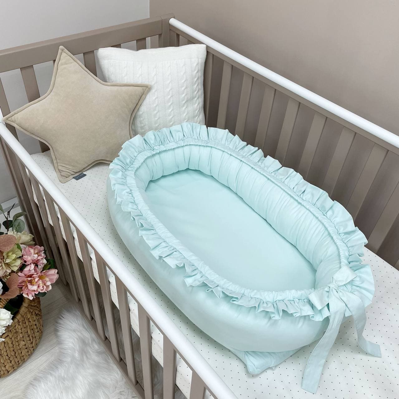 Baby nest cu volănașe mentă, vedere de ansamblu Baby nest mentă cu volănașe, cu fundă la picioare, fotografiat într-un pătuț