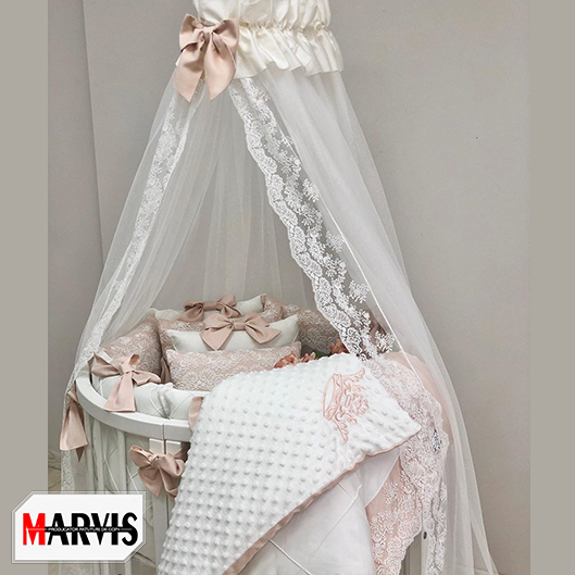 Set lenjerie pătuț Classic Ivory Set Classic Ivory pe un pătuț oval, cu baldachin cu dantelă și plăpumioară albă cu coroană