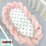 Baby Nest Braid Roz așezat pe un cearceaf gri, vedere de ansamblu