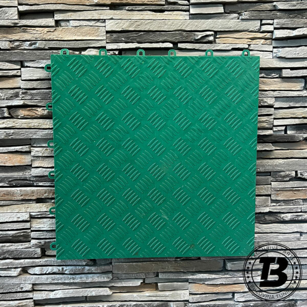 Placă de pardoseală modulară plină verde, cu model în relief, pe un perete din piatră