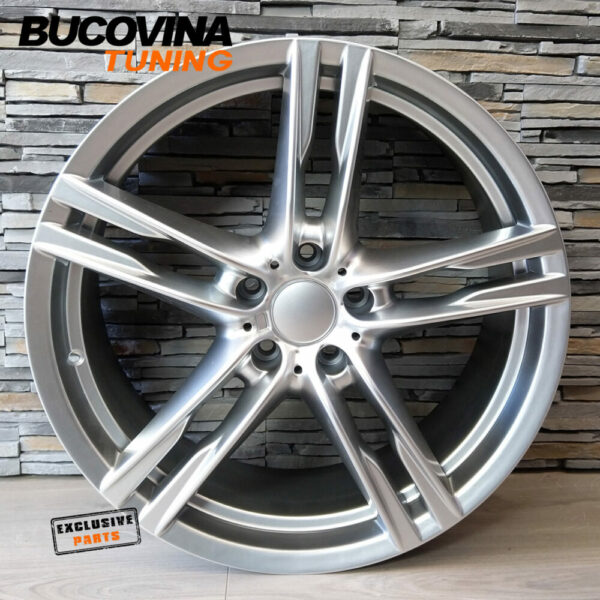 Jantă R20 5×120 Hyper Silver în stil M, cu cinci spițe duble, sprijinită de un perete de piatră