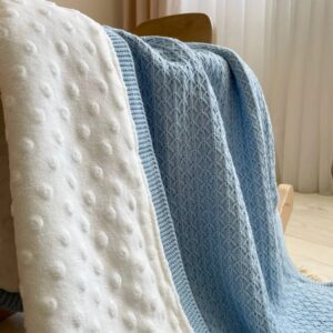 Detaliu cu minky alb cu puncte și tricot albastru cu model geometric fin