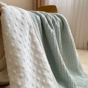 Detaliu cu minky alb cu puncte și tricot verde mentă cu model geometric fin