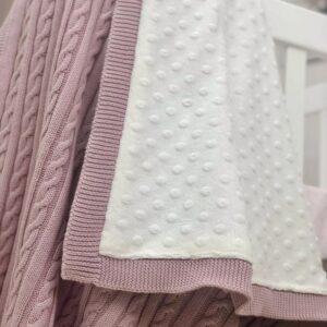 Detaliu Deluxe roz pudră: tricot cu împletituri și minky alb cu buline în relief