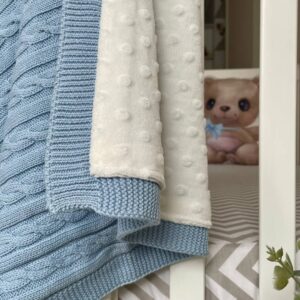 Detaliu Deluxe albastru: tricot bleu cu împletituri și minky alb cu buline în relief