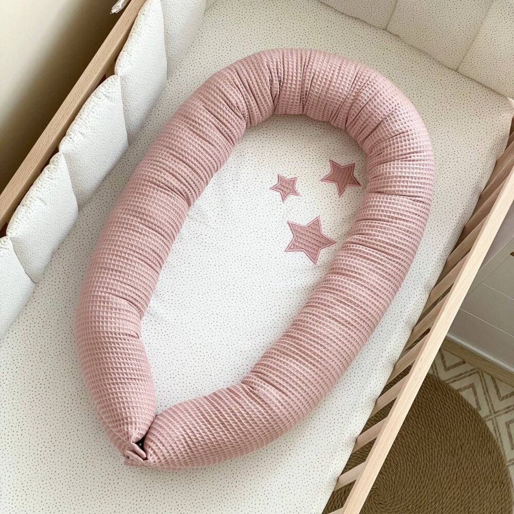 Baby Nest Stars vafe roz pudră, vedere de sus Baby Nest Stars vafe roz pudră cu steluțe cusute pe saltea, într-un pătuț, vedere de sus
