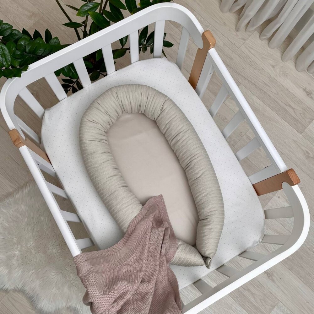 Baby nest Velvet latte Baby nest Velvet latte cu margini din tricot împletit, așezat în pătuț alb, vedere de sus