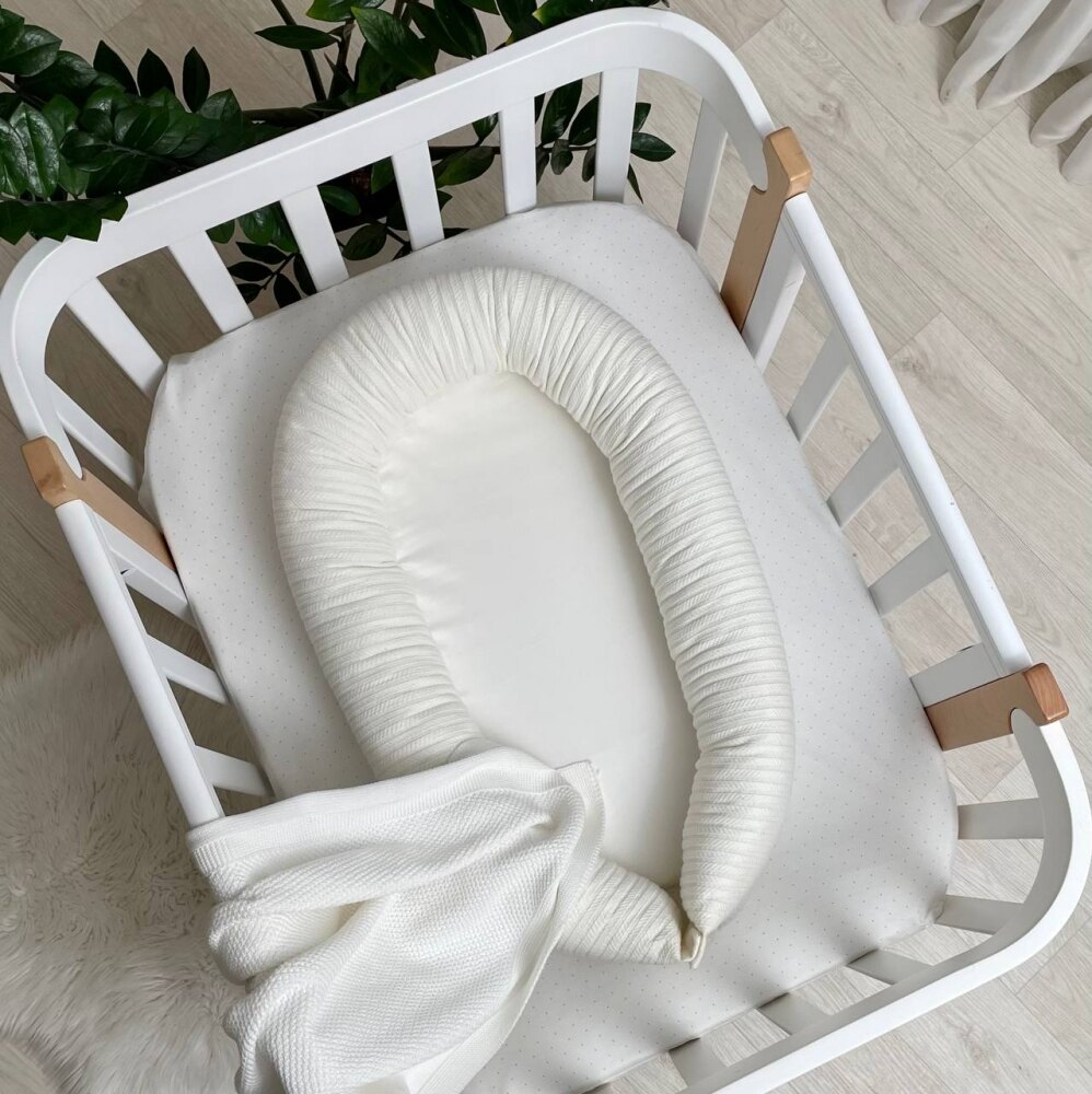 Baby Nest Velvet milky, vedere de sus Baby Nest Velvet milky alb lăptos, cu margine tricotată, într-un pătuț alb, vedere de sus