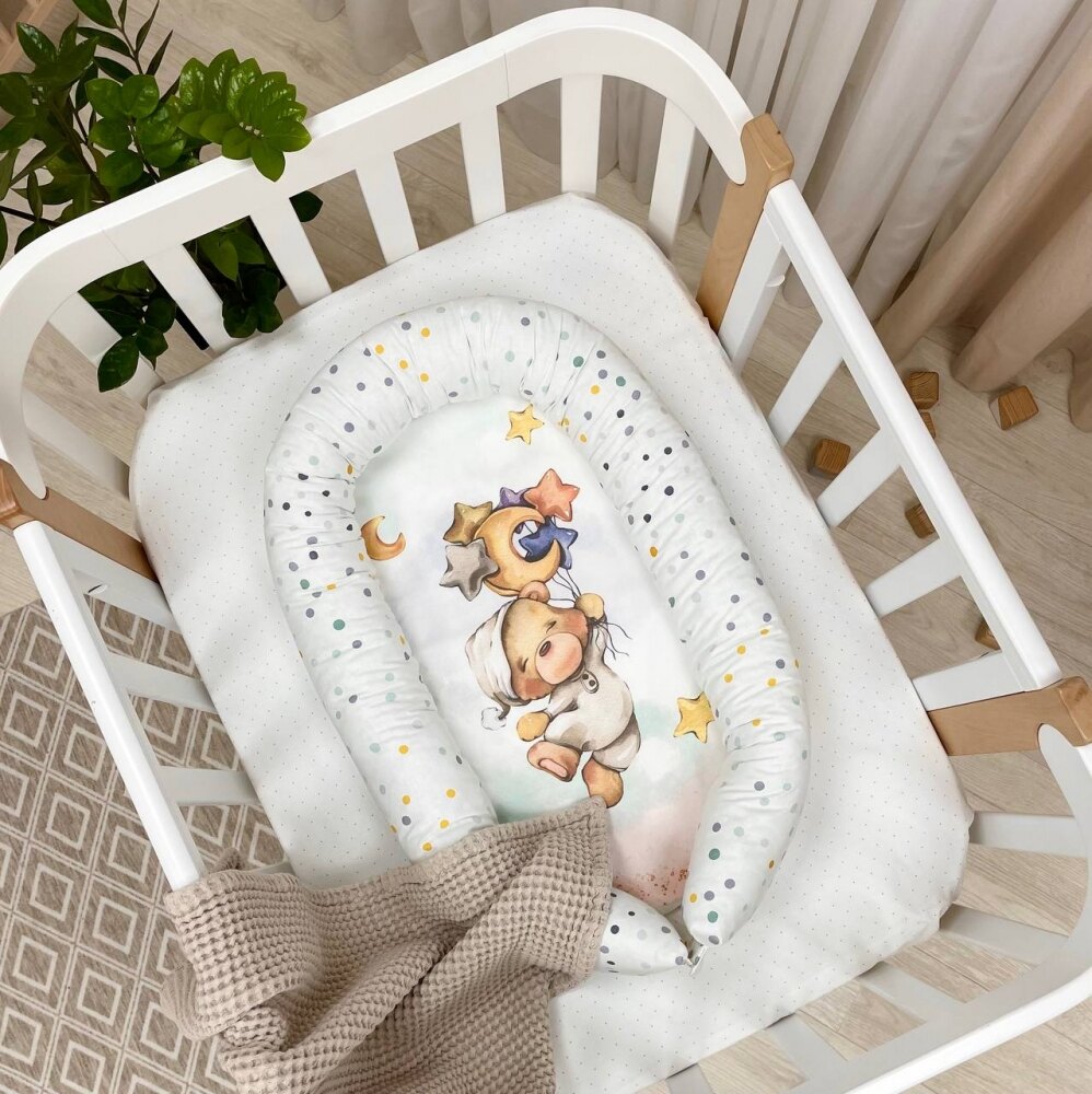 Baby nest Ursuleț bej Baby nest cu ursuleț în pijama bej pe un nor roz, lună și steluțe, margini cu buline, în pătuț