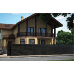 Casă din cărămidă galbenă cu gard jaluzea gri închis de-a lungul trotuarului
