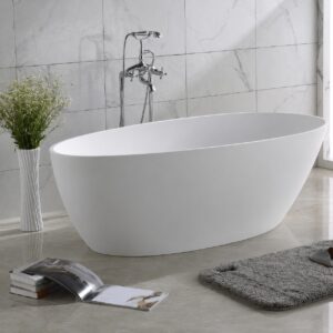 Cadă freestanding ovală din compozit alb mat, în baie cu faianță marmorată și baterie de pardoseală în decor