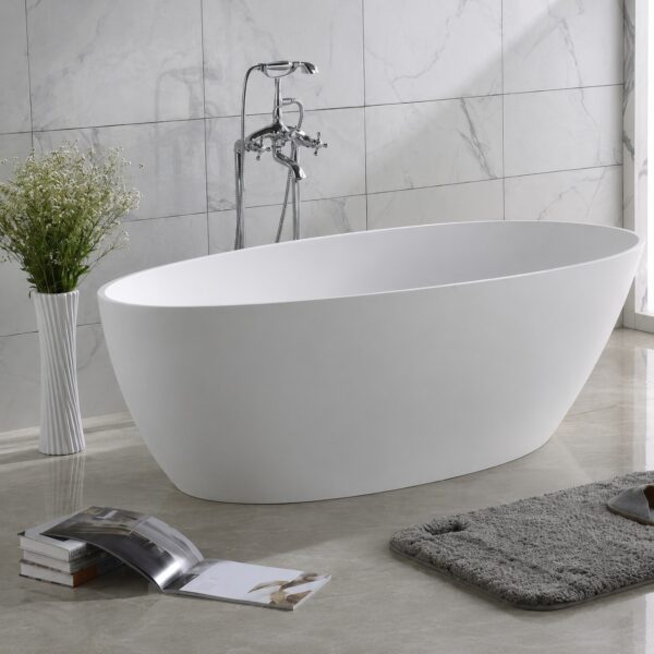 Cadă freestanding ovală din compozit alb mat, în baie cu faianță marmorată și baterie de pardoseală în decor