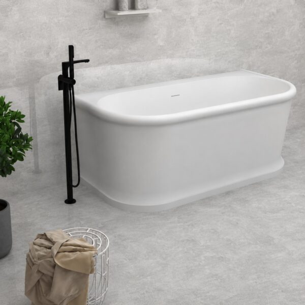 Cadă freestanding 2130280 din compozit alb mat, cu colțuri rotunjite și soclu, lângă o baterie de pardoseală neagră