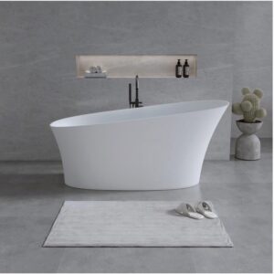 Cadă freestanding 2130320 din compozit alb mat, cu un capăt înălțat, într-o baie cu pereți gri