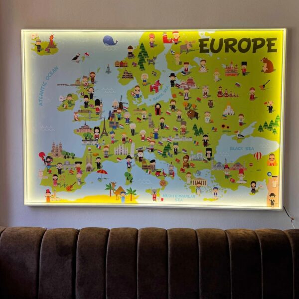 Hartă ilustrată a Europei cu iluminare LED pe contur, montată deasupra unei canapele maro