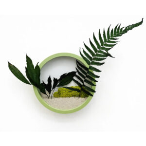 Jardinieră rotundă cu ramă verde mint, ferigă și frunze stabilizate, licheni verzi și pietriș alb, pe fundal alb