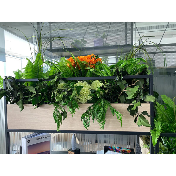 Jardinieră dreptunghiulară cu ferigi, hortensii verzi și flori portocalii artificiale, pe un raft negru