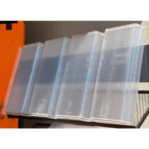 Luminatoare din policarbonat transparent cu 5 cute, stivuite pe un raft de depozit