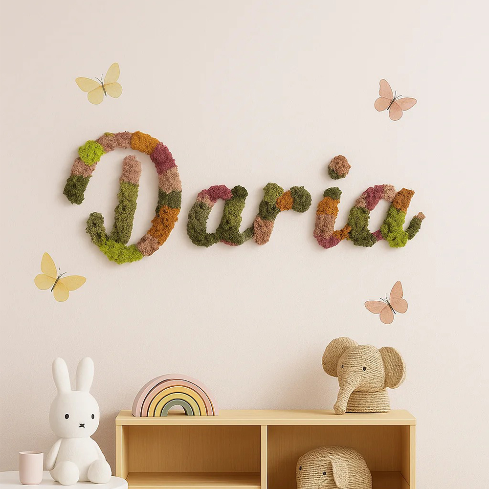Nume personalizat din licheni Daria, deasupra comodei Numele Daria din licheni colorați verde, roz și oranj pe un perete, deasupra unei comode, cu fluturi decorativi
