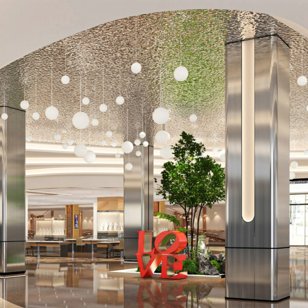 Atrium de centru comercial cu tavan și coloane placate cu panouri argintii ondulate, cu sfere luminoase suspendate