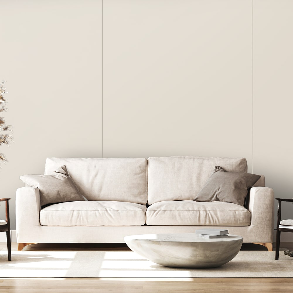Living cu canapea crem și măsuță rotundă din piatră, în fața unui perete din panouri Rocko 564 Almond cu rosturi fine Living cu canapea crem și măsuță rotundă din piatră, în fața unui perete din panouri Rocko 564 Almond cu rosturi fine