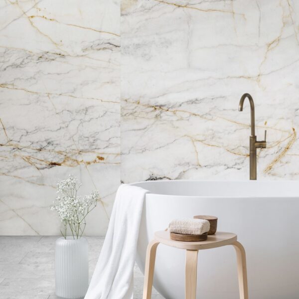 Cadă albă independentă cu baterie din bronz și taburet din lemn, pe un perete Rocko R154 Marble Gold cu vinișoare aurii