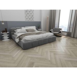 Parchet SPC Herringbone 64566 montat în spic într-un dormitor modern, cu pat tapițat gri și fotoliu