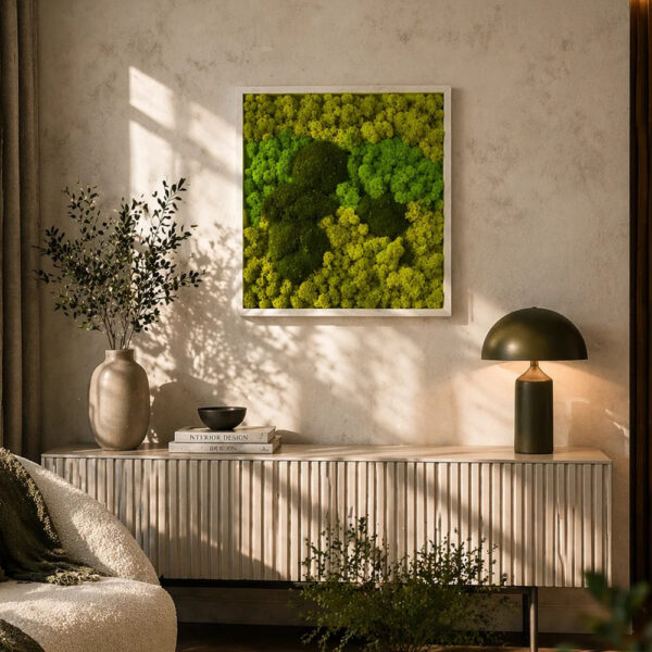 Tablou cu licheni și mușchi 50 × 50 cm, ramă albă, deasupra unei comode, lângă o vază cu ramuri și o lampă