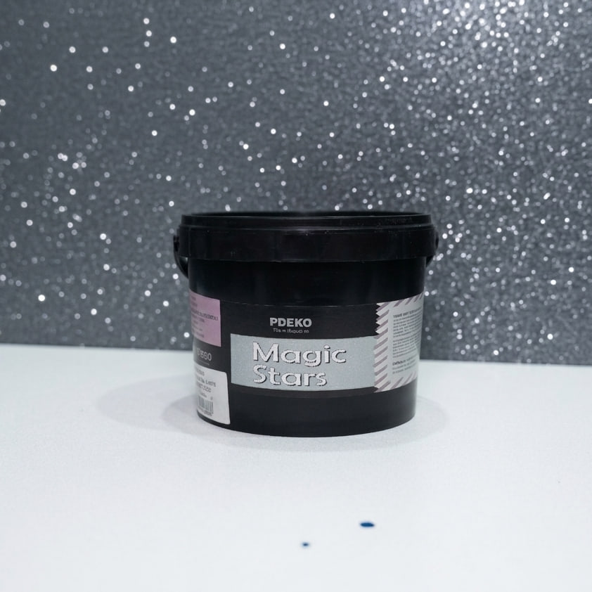 Găleată neagră de vopsea Magic Stars pe o masă albă, în fața unui perete gri cu sclipici argintiu Găleată neagră de vopsea Magic Stars pe o masă albă, în fața unui perete gri cu sclipici argintiu
